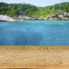 Wood table top on blurred blue sea background used for display y