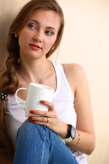 Young woman at home sipping tea from a cup