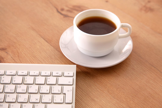 Office desk table with computer, supplies and coffee cup