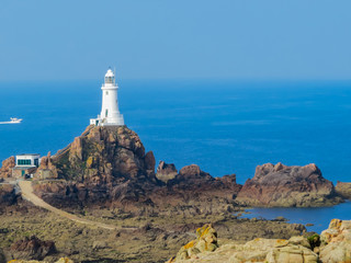 Fototapeta na wymiar La Corbiere Lighthouse on the rocky coast of Jersey Island