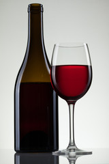 Glass of wine and bottle on white with copy space