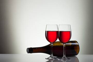 Glass of wine and bottle on white with copy space