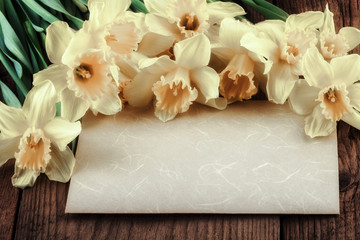 Obraz na płótnie Canvas Vintage daffodil flowers with paper sheet