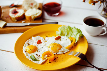 Two fried eggs for healthy breakfast on white wooden table