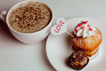 Beautiful coffee Cup with heart cupcake on white wooden background