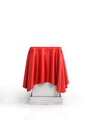 Presentation pedestal covered with a red silk cloth on white bac