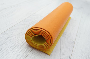 bright orange yoga mat on a light gray laminate, indoors