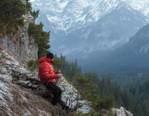 Well built mountain guide having rest at astonishing winter rocky landscape background