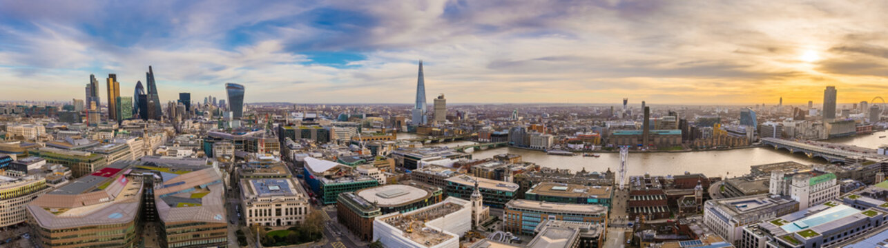 Panoramic skyline of east and south London at sunset. This wide view includes the famous financial Bank district, famous skyscrapers, Tate modern, River Thames and the Millennium Wheel - London, UK