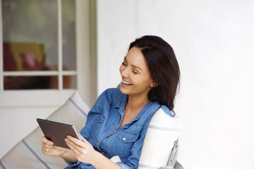 Young woman looking at digital tablet and laughing