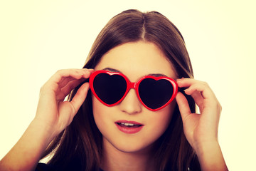 Shocked teen woman wearing sunglasses.