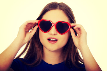 Shocked teen woman wearing sunglasses.