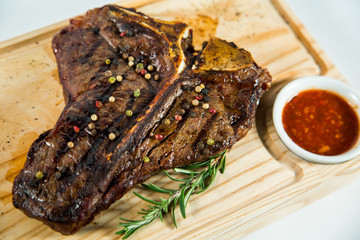 Beautiful juicy well done steak with sauce on a wooden Board