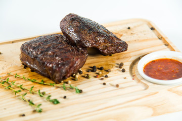 Beautiful juicy well done steak with sauce on a wooden Board