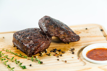Beautiful juicy well done steak with sauce on a wooden Board