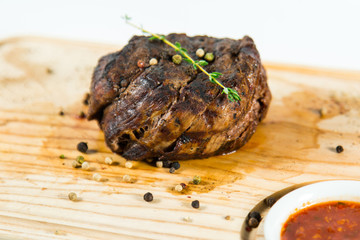 Beautiful juicy well done steak with sauce on a wooden Board