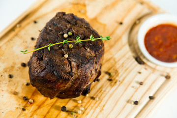 Beautiful juicy well done steak with sauce on a wooden Board