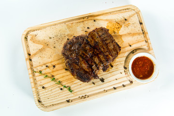 Beautiful juicy well done steak with sauce on a wooden Board
