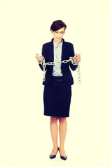 Businesswoman wrapped with metal chain.