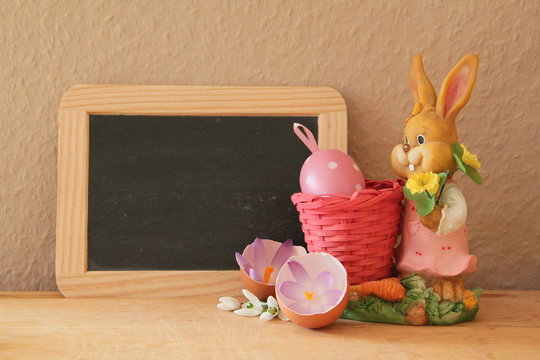 Osterhase neben Schiefertafel mit Platz f&uuml;r Text