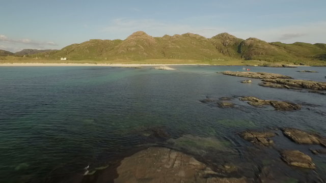 Aerial shot along the beach on the coastline during a sunset at Ardnamurchan, Scotland
