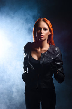 Gorgeous, young, redhead woman in black leather jacket being chased in the dusk.