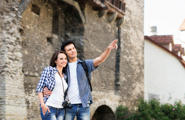 Fototapeta na wymiar Young couple being tourists exploring the medieval buildings