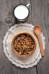 Granola in wooden bowl and milk