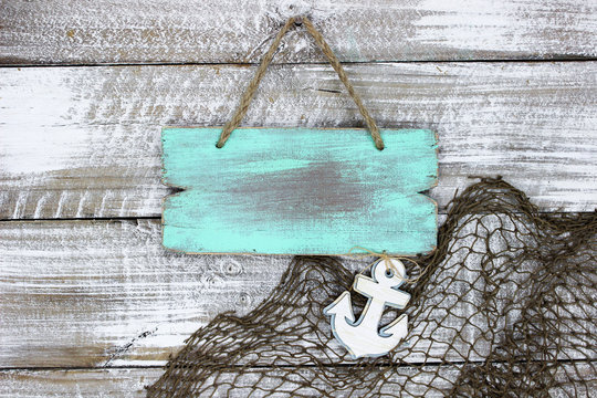 Blank Wood Mint Green Sign And Fish Net With Anchor Hanging Wood Background