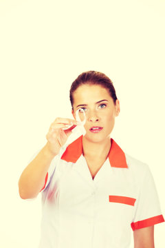 Young Female Doctor Or Nurse Holding Pink Breast Cancer Awareness Ribbon