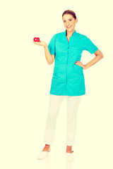 Young female doctor or nurse holding heart toy