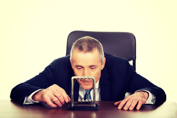 Businessman in office playing with newton balls