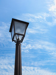 Fototapeta na wymiar Bottom view antique lamppost on blue sky