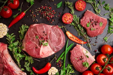 Crédence de cuisine en verre imprimé Viande Raw meat steaks on a dark background ready to roasting