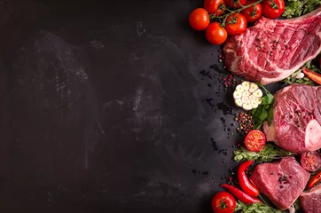 Fotobehang Vlees Rauw vlees steaks op een donkere achtergrond klaar om te braden