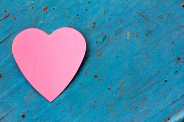 Valentine - paper pink heart against a blue painted surface. Copy space. Free space for text, Close-up, top view