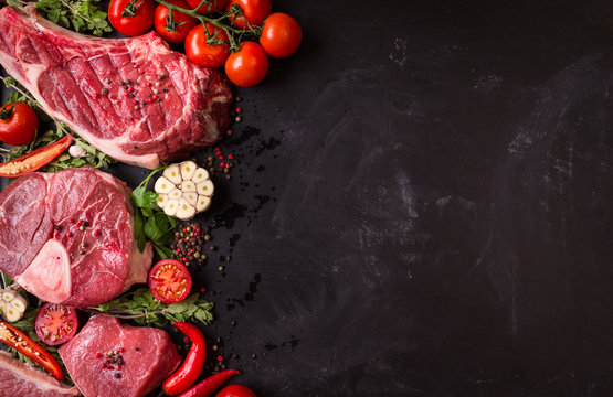 Raw meat steaks on a dark background ready to roasting