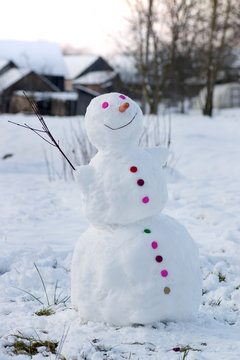 Smiling snowman in a village
