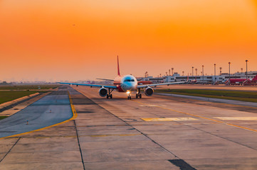 Airplane ready to taking off runway at the sunset time