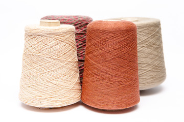Cones of colored threads of wool on a white background