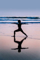 Young woman practicing yoga on beach in Agonda, Goa, India