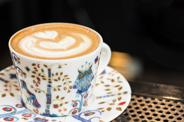 Cup of latte art on table in cafe