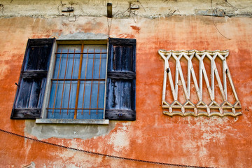 Fototapeta na wymiar Old window and scraped wall in ancient house