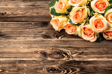 Pink roses bouquet on rustic wooden boards. Flowers background with copy-space