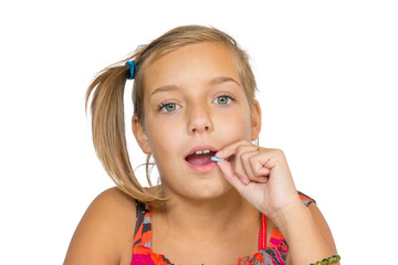 Portrait of child girl taking medicine tablet into mouth, isolated on white background