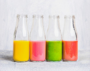 Colorful smoothies assortment  in glass bottles on light table, side view. Superfoods and health or detox  diet food concept.