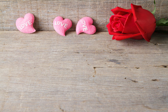 Valentines day background with pink hearts and rose on wooden ba
