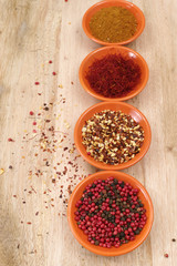 Four bowls with saffron, pepper, ras en hanout, chili with garlic