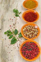 Four bowls with saffron, pepper, ras en  hanout, fresh mint