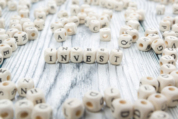 invest word written on wood block. wooden abc.